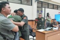 Oditur Militer memeluk anak bos rental mobil, Rizki Agam Sahputra yang menangis saat vidio penembakan sang ayah diputar di persidangan di Pengadilan Militer II-08 Jakarta, 3 Maret 2025. 